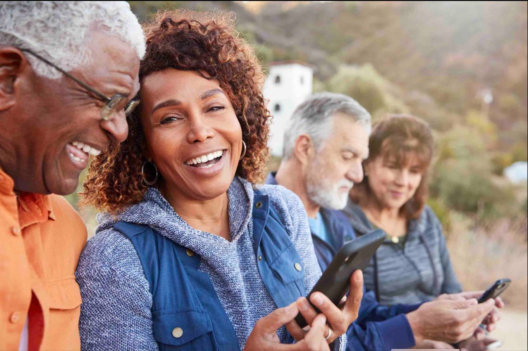 A group of friends laughing together while looking at a phone