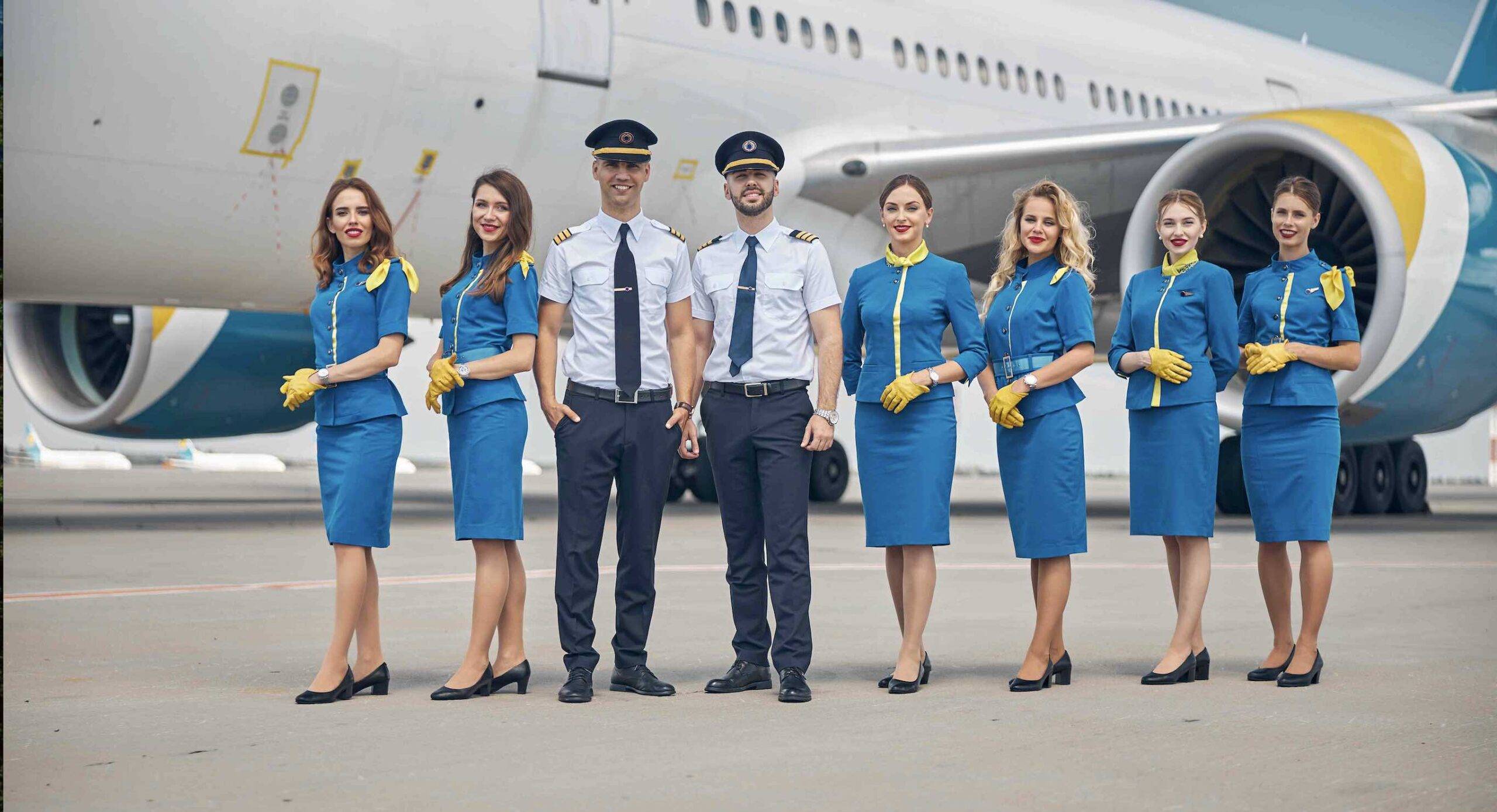 A team of airline pilots and cabin crew standing in front of an aircraft